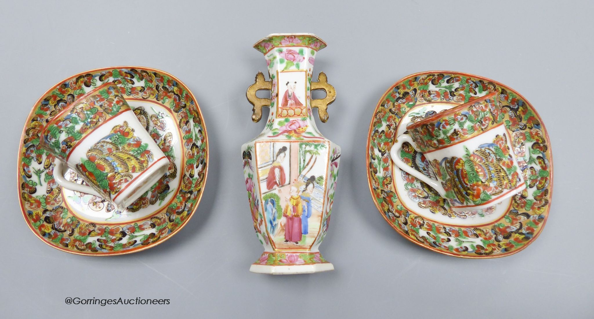 A Chinese famille rose small vase and two cups and saucers